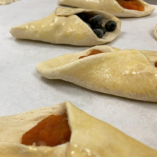 Collection of frozen danishes, some apricot, some apple, and some blueberry.