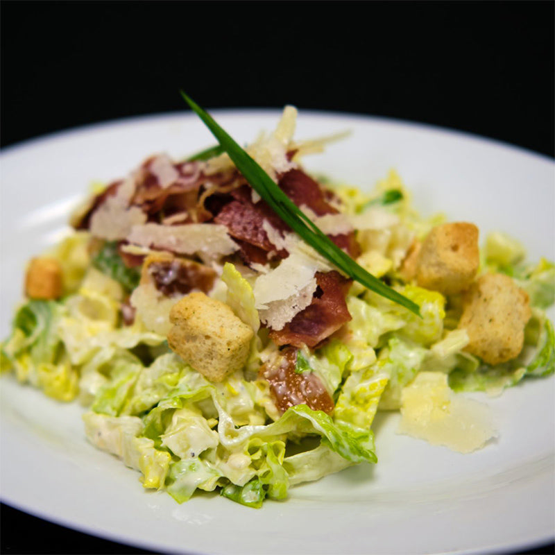 Salad made of romaine lettuce, bacon, fresh croutons and homemade caesar dressing.