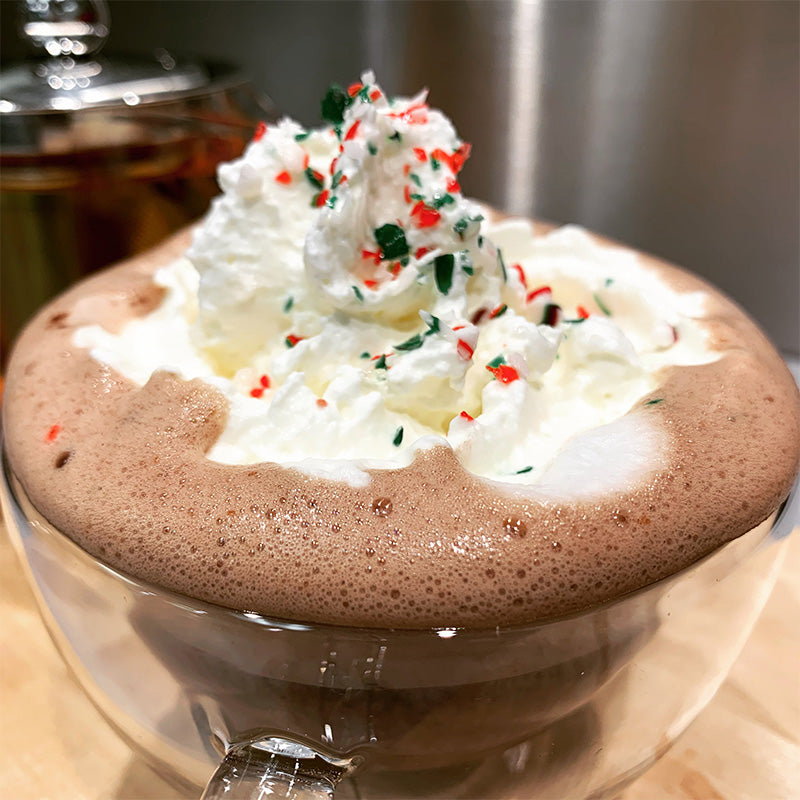 Hot chocolate with steamed Ontario milk, freshly-made whipped cream, optional sprinkles, and chocolate syrup.
