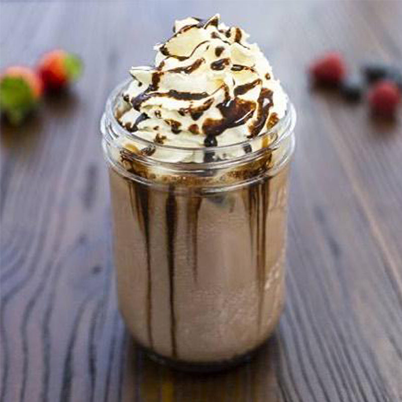 Large glass mason jar with coffee cubes, chocolate milk and chocolate sauce, with whipped cream and chocolate sauce on top.