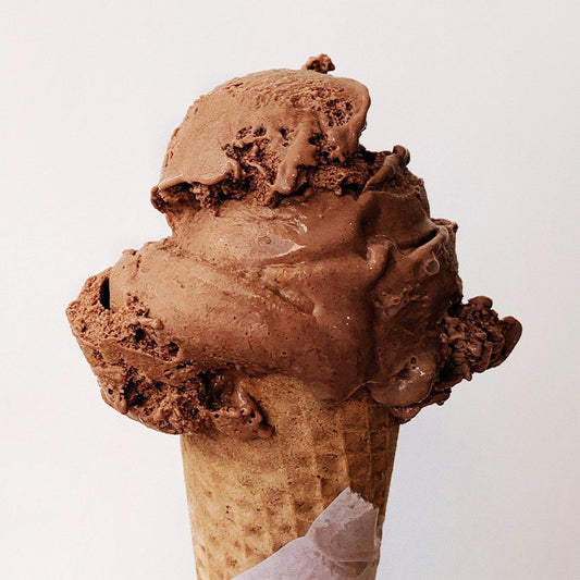 Large scoop of chocolate ice cream in an ice cream cone.